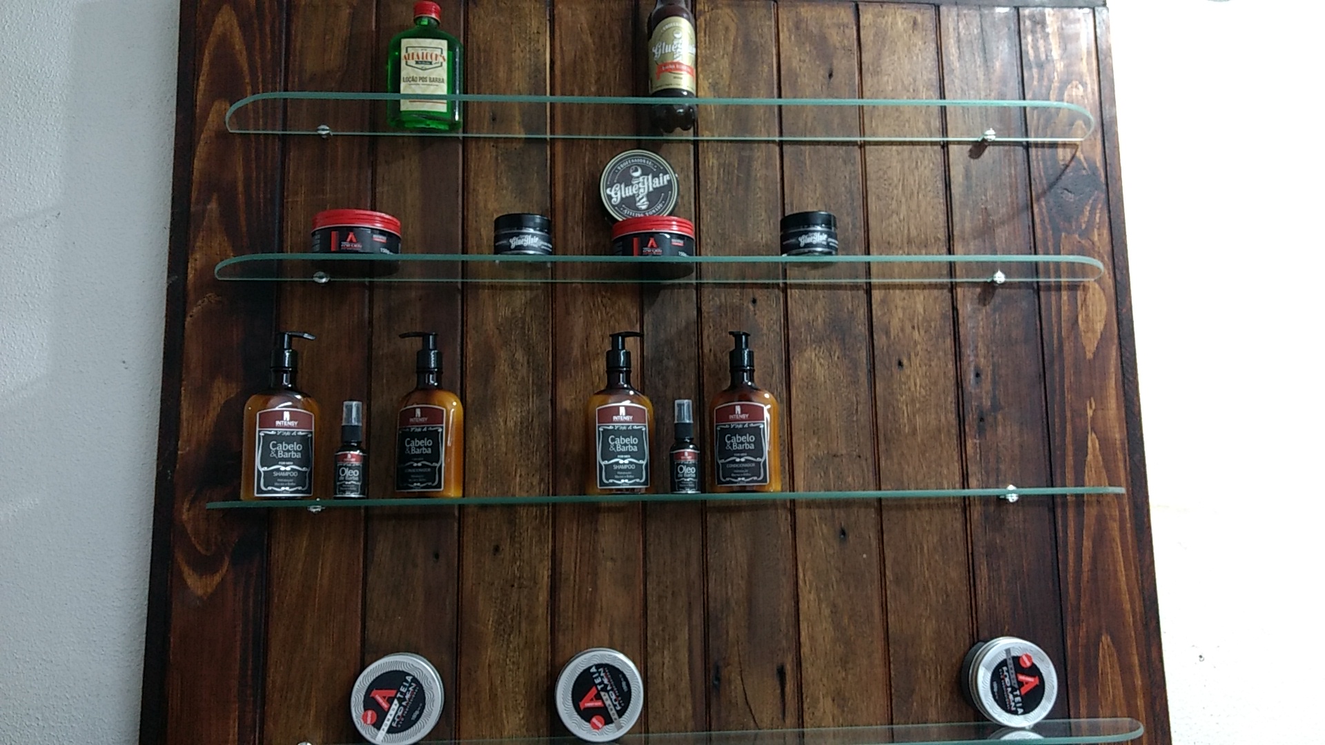 Prateleira com produtos de cabelo e barba na Navalha De Aço Barbearia