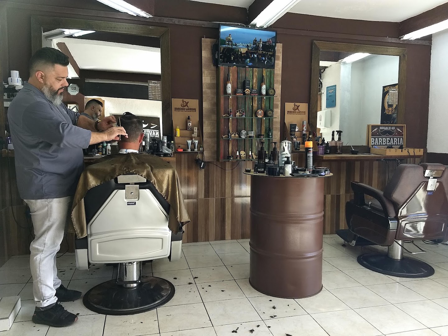 Barbeiro cortando o cabelo de um cliente na Navalha De Aço Barbearia, no Alto Boqueirão