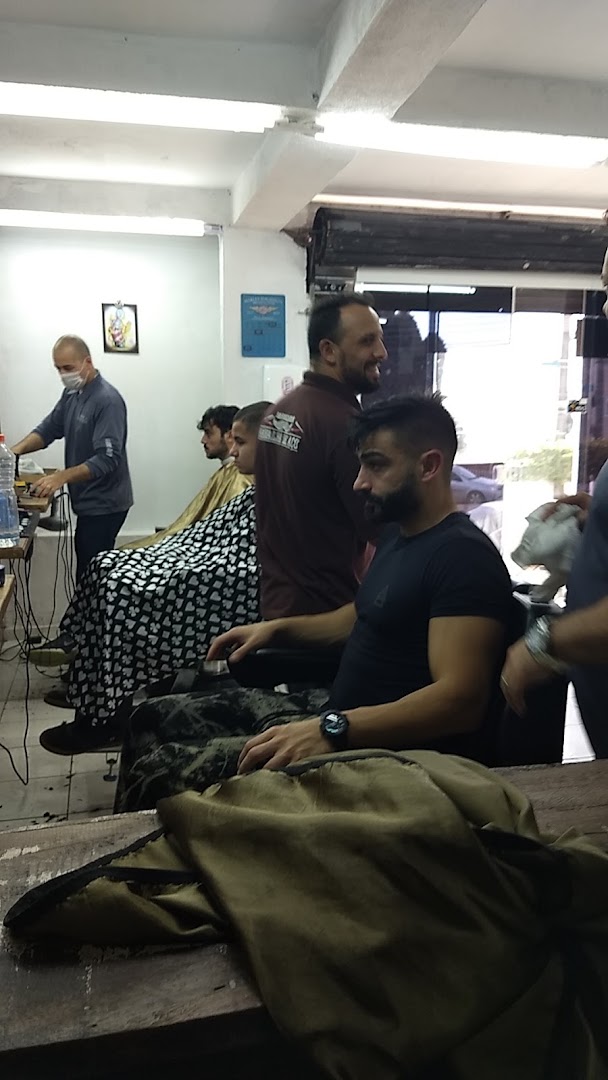 Clientes sentados e sendo atendidos dentro da Navalha De Aço Barbearia